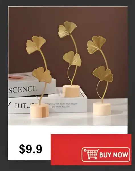 Golden metallic ginkgo leaf sculptures on beige bases displayed with a shatterproof clear acrylic cylinder vase by decorbites