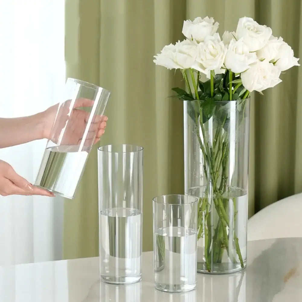 Tall shatterproof clear acrylic cylinder vases of varying heights arranged on a reflective surface by decorbites