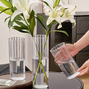 Decorbites shatterproof clear acrylic flower vase with vertical ribbed texture holding white lilies in water