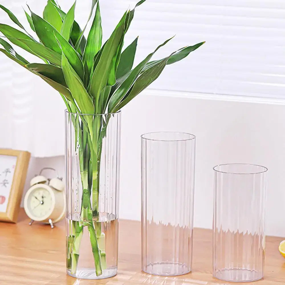 Decorbites shatterproof clear acrylic flower vase with ribbed design holding a lush green bamboo plant