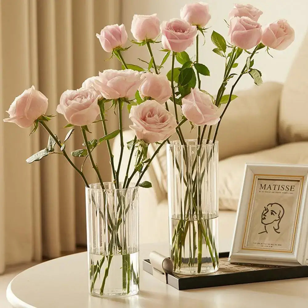 Two shatterproof clear acrylic flower vases with vertical ridges each holding soft pink roses by DecorBites™