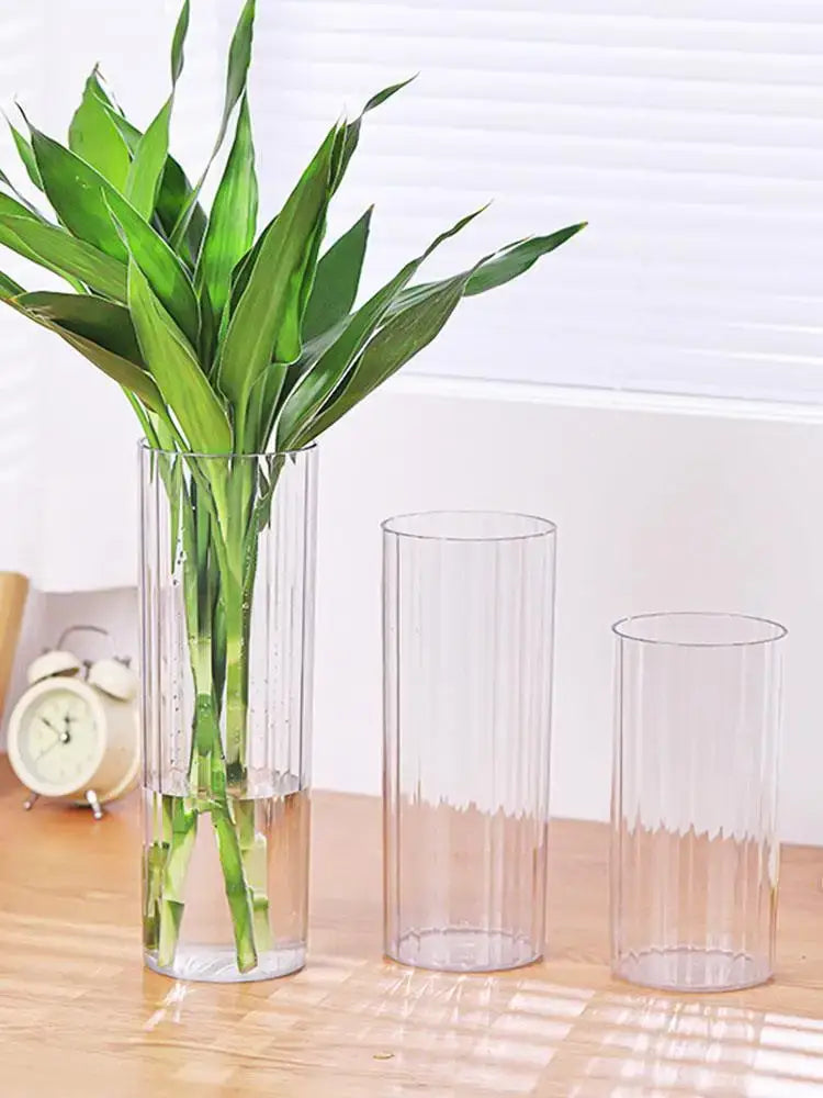 Decorbites shatterproof clear acrylic flower vase with vertical ribs holding a lush green bamboo plant