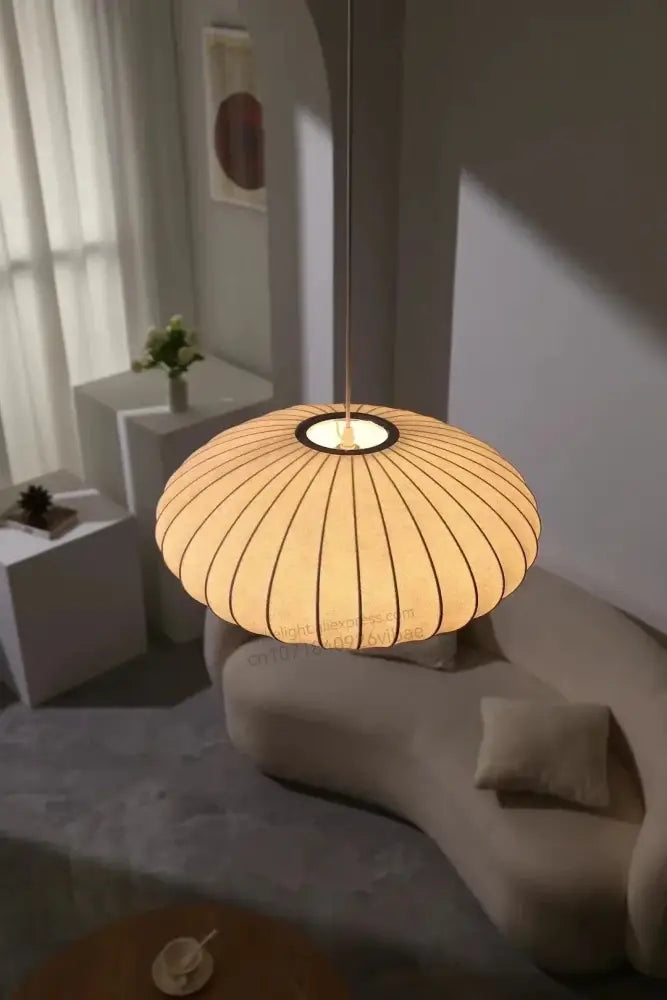 Warm-toned silk led pendant lamp with ribbed paper shade and sleek black circular base by decorbites modern lighting