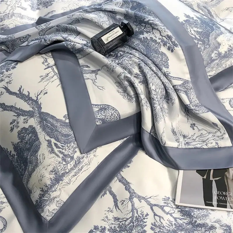 A luxurious ivory silk scarf with blue toile print and gray satin border paired with eucalyptus fiber duvet cover