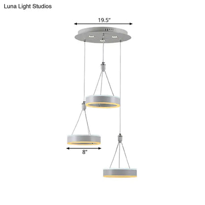 Modern white and silver cluster ceiling light with three tiered metallic rings and warm yellow led glow for dining room