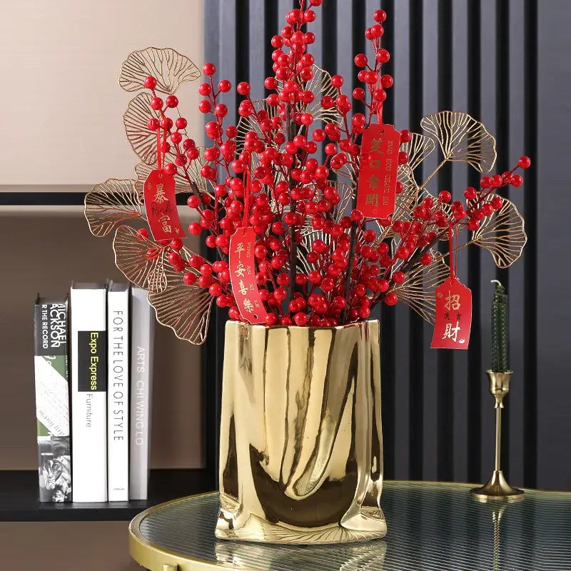 DecorBites™ silver ruffled flower vase in gold metal with vertical ridges holding red berries and gold ginkgo leaves