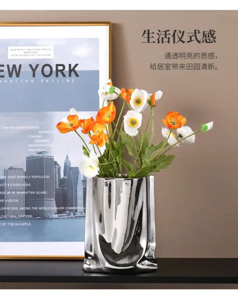 DecorBites silver ruffled flower vase in shiny silver ceramic holding orange and white poppies with sculpted design