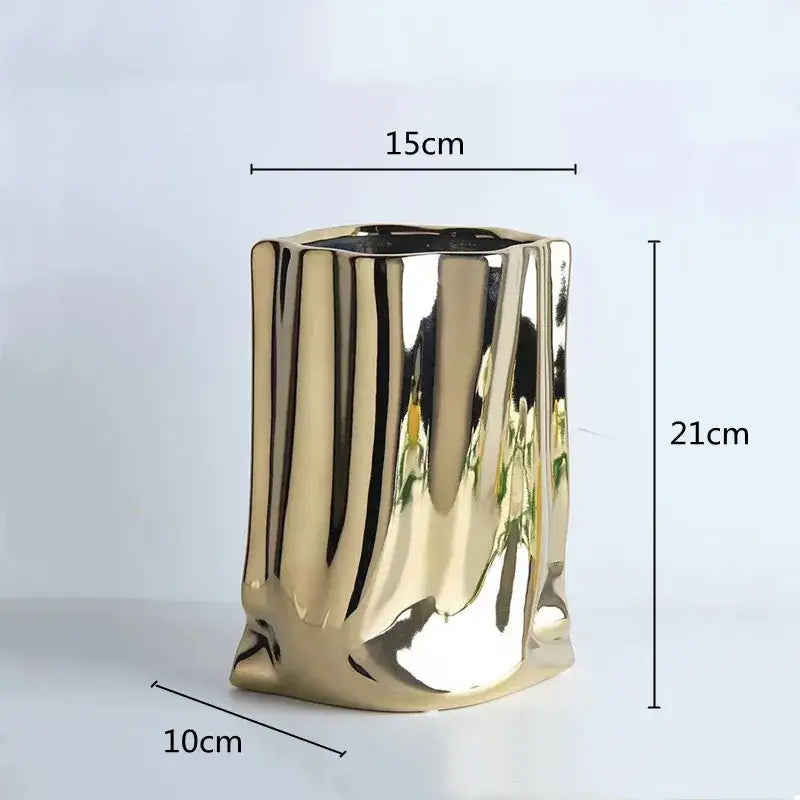 A sleek gold ceramic silver ruffled flower vase with a modern ribbed design and reflective surface by decorbites