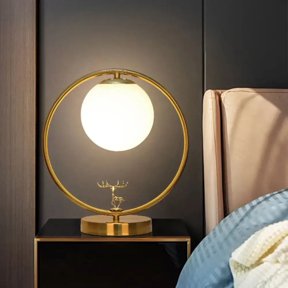 Gold-toned circular table lamp with ivory glass ball shade and delicate deer base for 220v-240v 110v-120v use