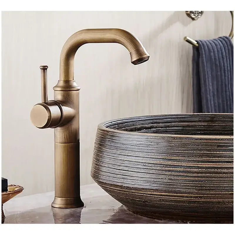 DecorBites single handle antique brass bathroom faucet with curved spout and cylindrical base in brass finish