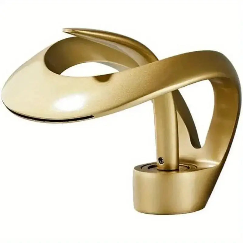 Golden metallic abstract sculpture resembling a single handle bathroom sink faucet with flowing polished curves