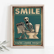 A framed decorbites skeleton man squatting toilet canvas wall art with vintage teal background and weight loss text