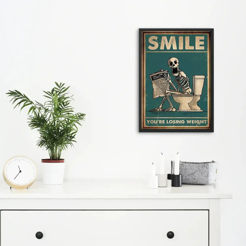 Vintage-style teal canvas wall art of a skeleton man squatting on a toilet reading a newspaper with beige text decorbites