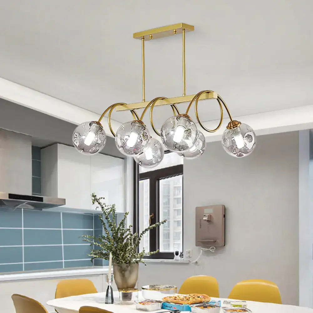 Decorbites sleek gold spiral island light with five clear glass globes and curved metal arms in gold finish