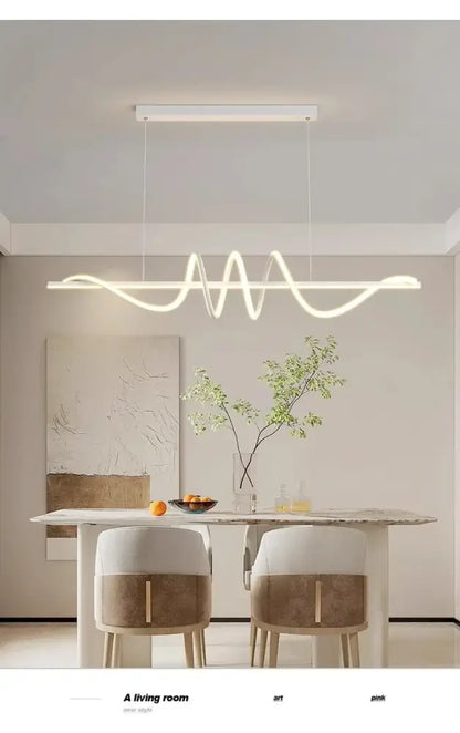 Modern white led pendant lights with sleek wavy design hanging above dining room table by DecorBites