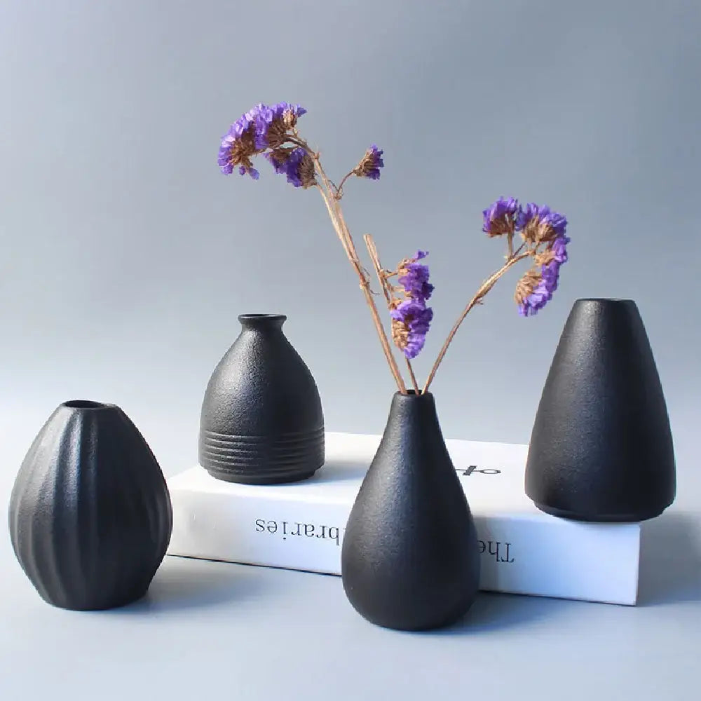 Set of four matte black ceramic small vases with organic shapes and textured surfaces for elegant japanese home decor
