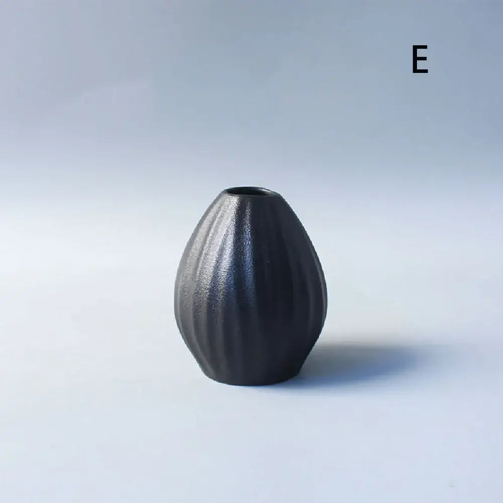 A sleek matte black ceramic small vase with ribbed texture and teardrop shape for elegant japanese home decor