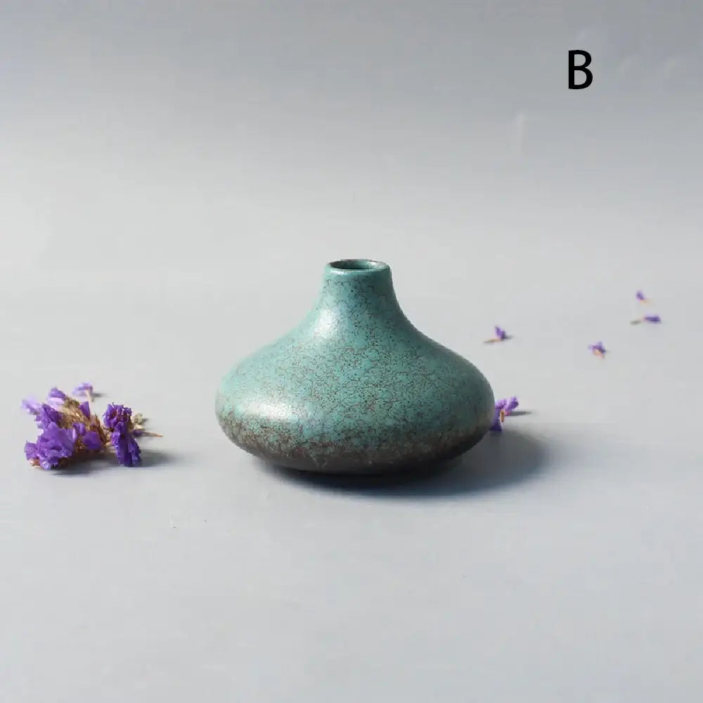 A small teal ceramic vase with crackled glaze and rounded body for elegant japanese home decor by DecorBites