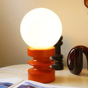 Warm orange ceramic base supports a glowing white spherical lamp in the DecorBites small table lamp Bauhaus design