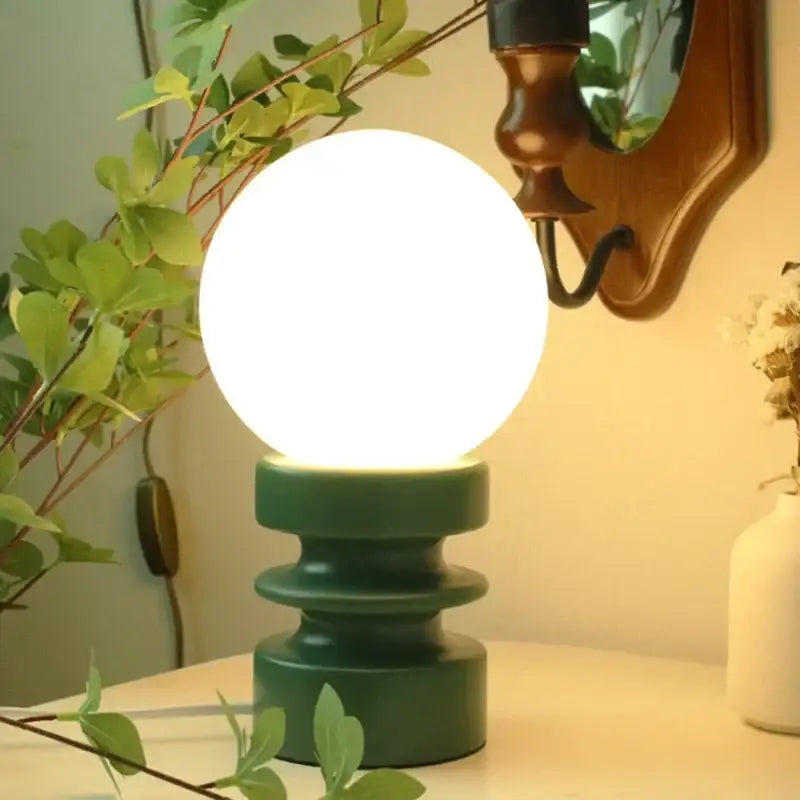 DecorBites small table lamp bauhaus with a glowing white spherical lamp and dark green tiered ceramic base