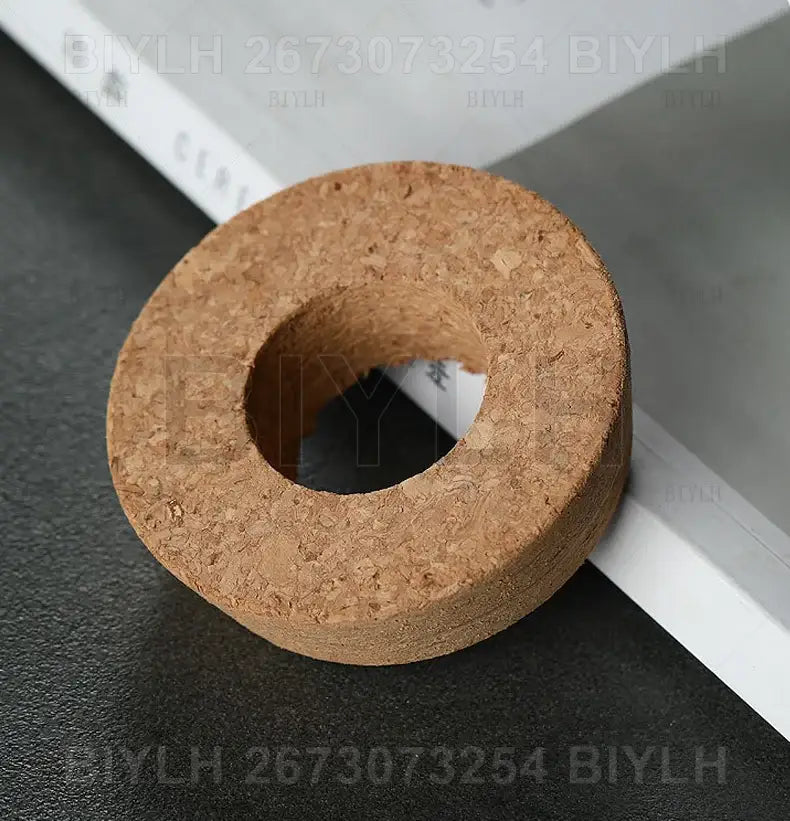 A natural brown cork stopper with a textured surface and central hole for decorbites small transparent glass vase