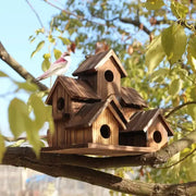 Rustic wooden DecorBites™ small hanging bird house with multiple gabled roofs and circular entry holes on branch