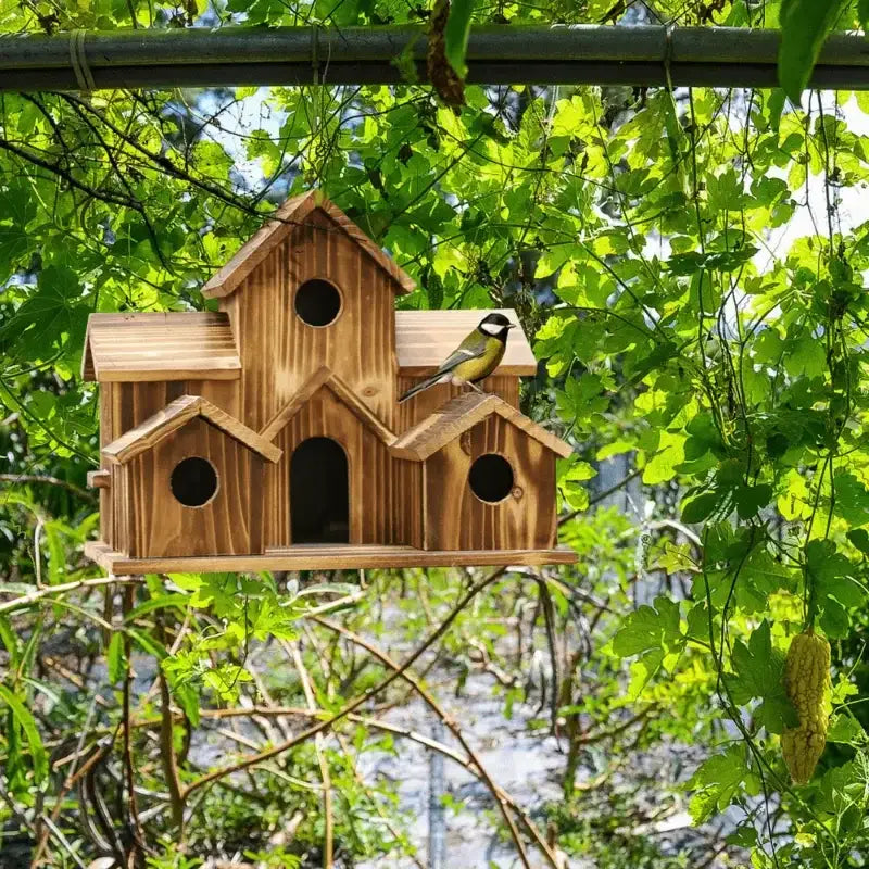 DecorBites™ small wooden hanging bird house with multiple entry holes and a bird perched on its roof in rustic wood