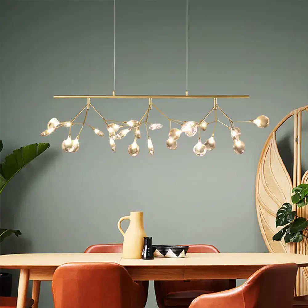 Gold-toned modern chandelier with branching arms and clear glass globe bulbs in smoke grey glass firefly design