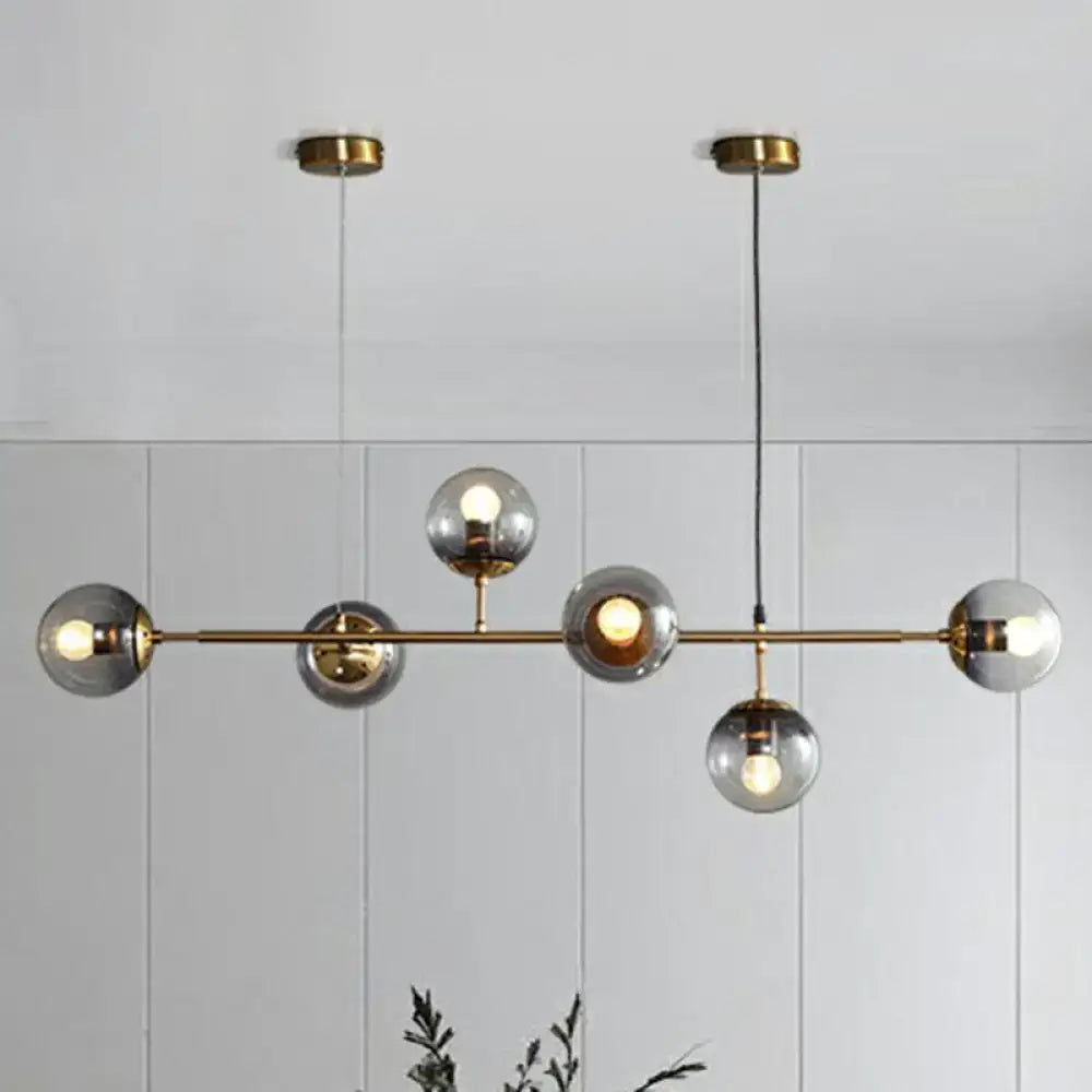 Modern brass finish pendant light with smoke grey glass and six spherical bulbs ideal for restaurants