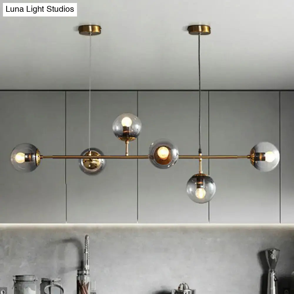 Modern brass pendant light with five frosted glass globe bulbs and brass finish, ideal for restaurants lighting