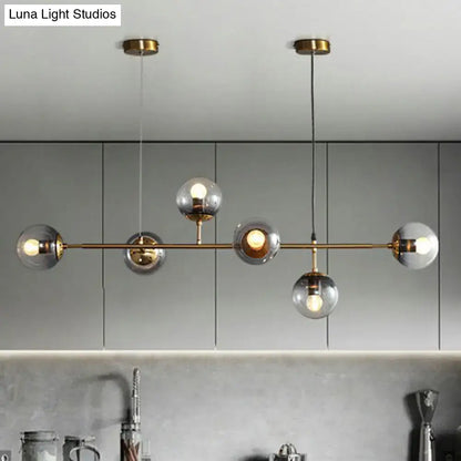 Modern brass pendant light with five frosted glass globe bulbs and brass finish, ideal for restaurants lighting