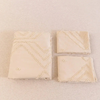 Cream-colored embroidered microfiber napkins with zigzag stitching and diamond motifs from a duvet cover set