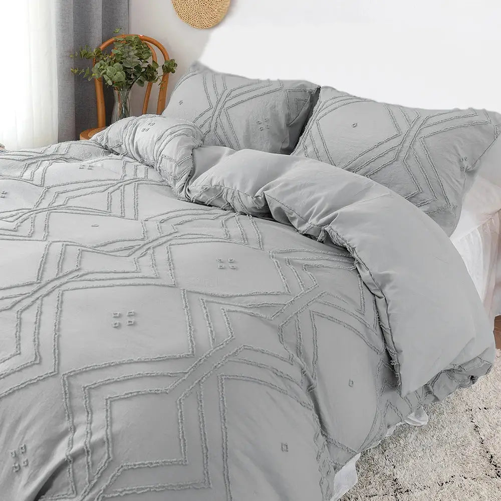 Gray quilted duvet cover set with geometric embroidery and ruffled edges made of soft tufted microfiber by decorbites