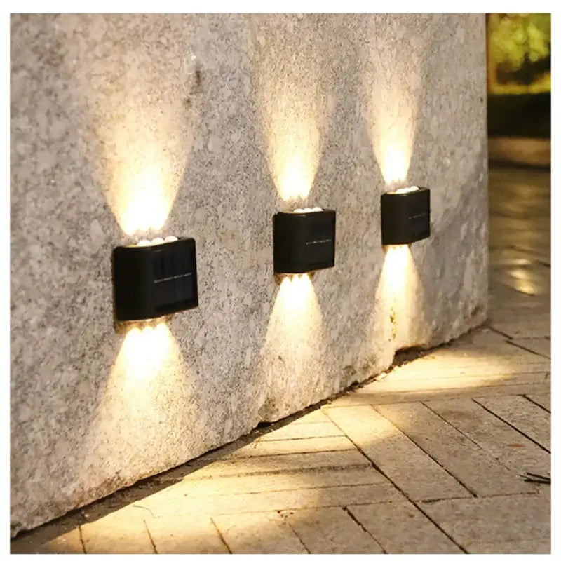 DecorBites™ solar led black rectangular wall light with lamp beads casting warm beams on stone pathway