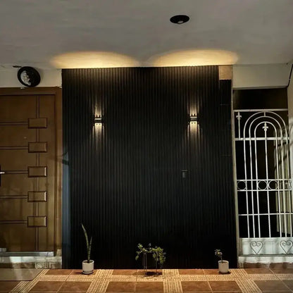 Black vertical panel wall featuring sleek modern design with solar led outdoor wall lights by decorbites for garden use