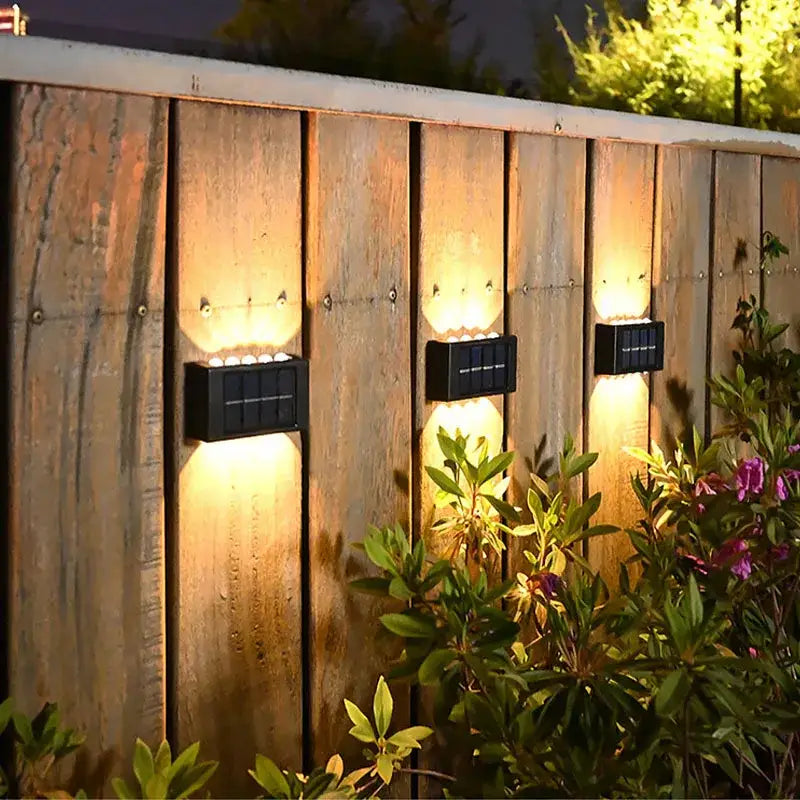 Black rectangular decorbites™ solar led outdoor wall lights with integrated led bulbs mounted on wooden fence