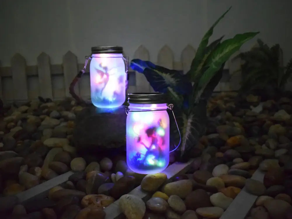Two glowing translucent glass solar mason jars with metal lids and handles illuminated by purple and blue led lights
