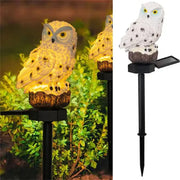 Decorbites™ solar owl garden light with white resin body, black speckles, yellow eyes on dark brown tree stump base