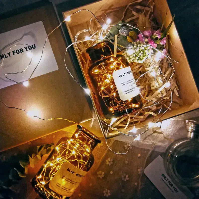 Amber glass jar labeled blue mountain filled with warm fairy lights from decorbites solar wine bottle decoration