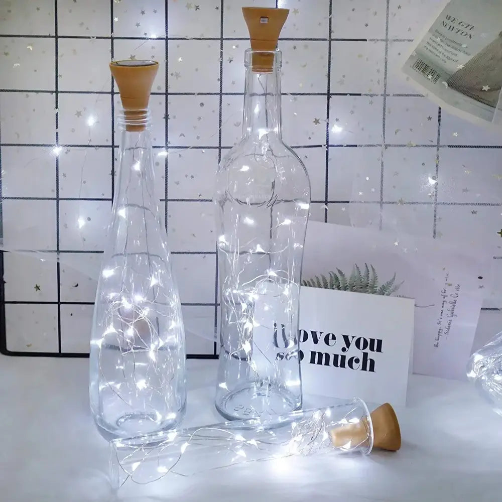 Clear glass solar wine bottles with cork stoppers and embedded fairy lights for home decoration by decorbites