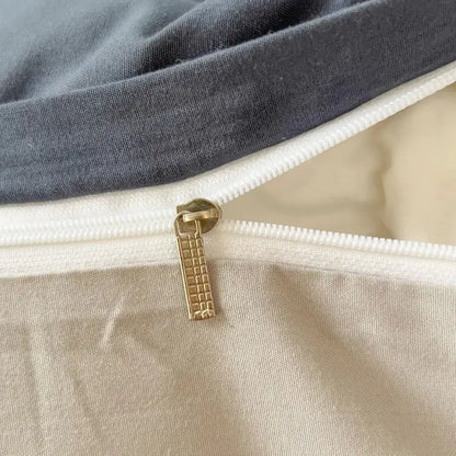 Gold-toned zipper pull with textured grid design on gray and beige solid color brush fabric duvet cover set by decorbites