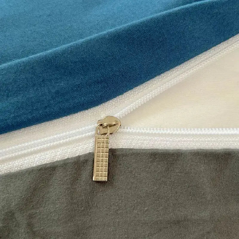 Gold-toned zipper pull with textured grid on solid color blue brush fabric duvet cover from DecorBites bedding set