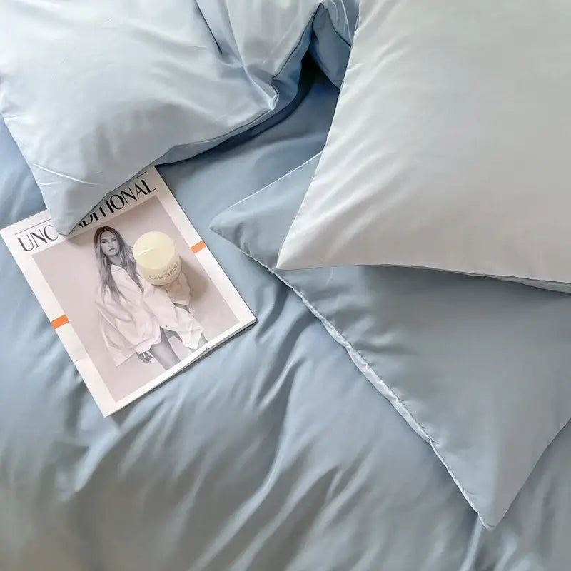 Light blue solid color brush fabric pillowcases with subtle sheen arranged on matching duvet cover bedsheet set decorbites