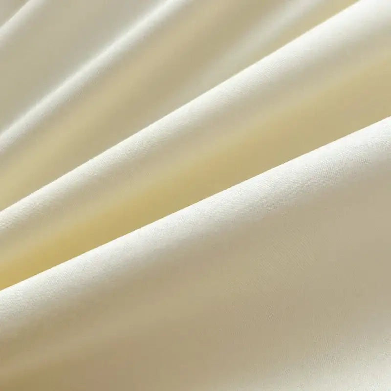 Soft cream-colored satin decorbites™ solid color brush fabric duvet cover with smooth reflective surface and gentle folds