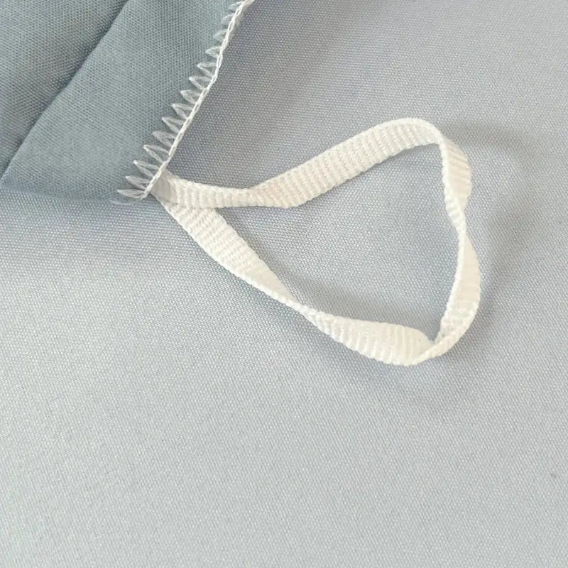 White ribbed drawstring with zigzag stitching on light blue solid color brush fabric duvet cover from decorbites bedding set