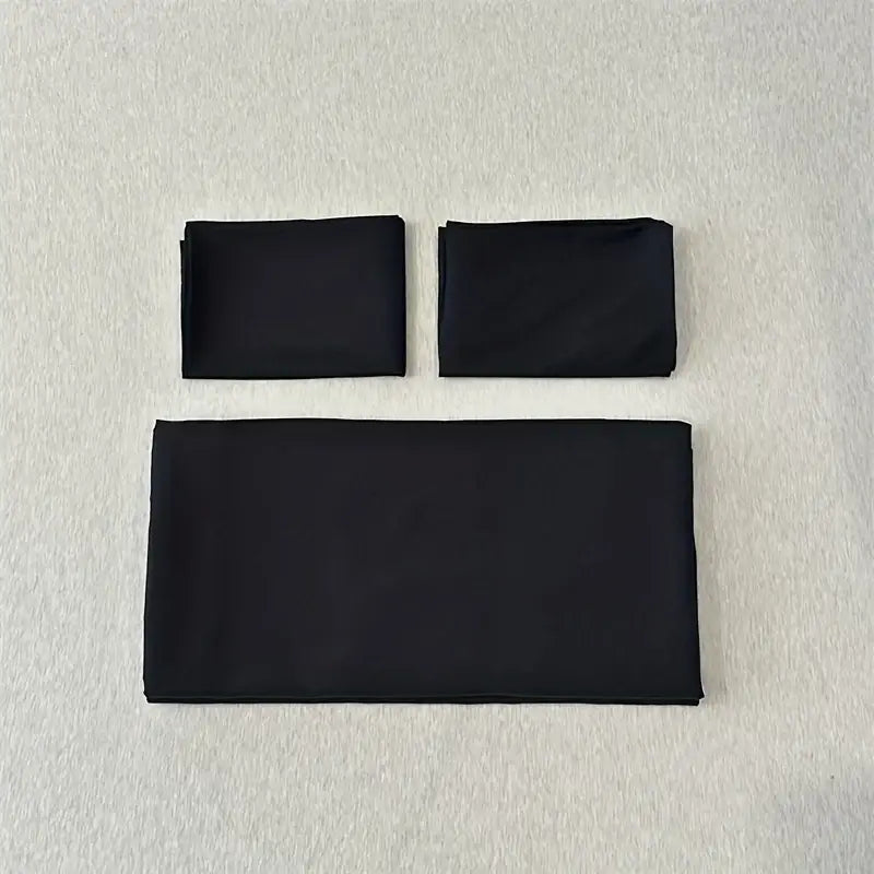 Set of three black folded fabric napkins complementing the DecorBites™ solid color brushed duvet cover set