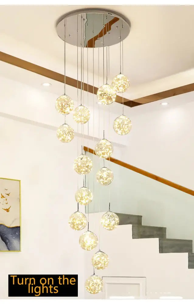 A modern DecorBites™ spiral crystal ball chandelier with multiple glowing glass orbs suspended from chrome fixture