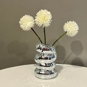 DecorBites™ spiral vase with a reflective mosaic plastic spiral design holds three fluffy white creative flowers