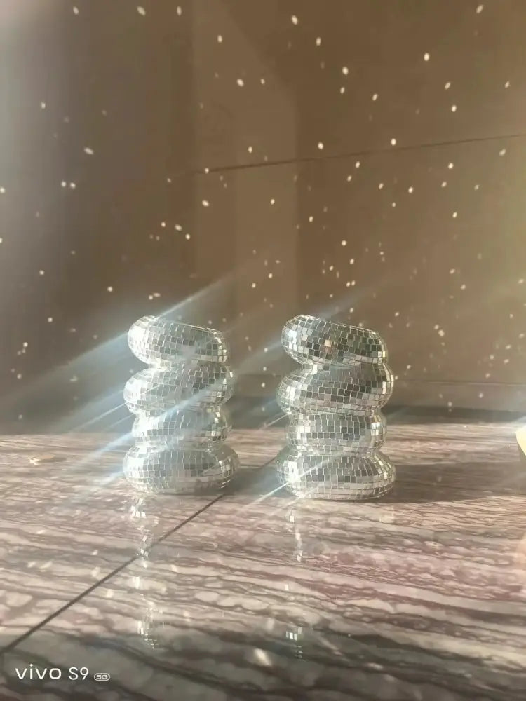Two silver mirrored disco ball sculptures with stacked spiral design mimic a decorbites spiral vase for creative flower arrangements mosaic plastic spiral