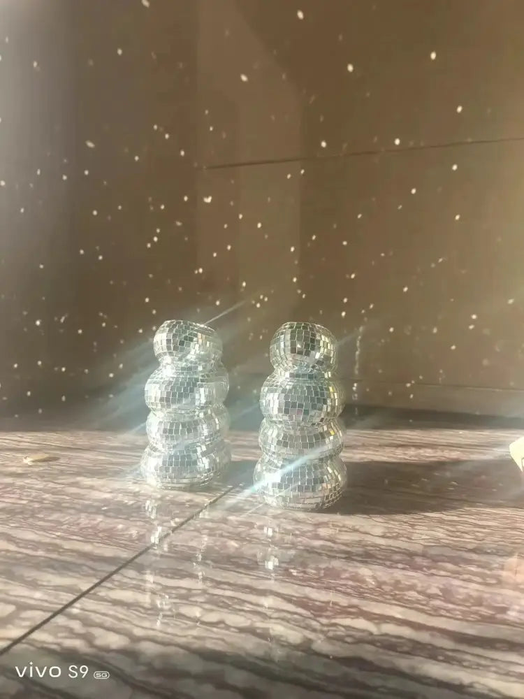 Two silver mosaic plastic spiral disco ball figurines stacked as decorbites spiral vase for creative flower arrangements